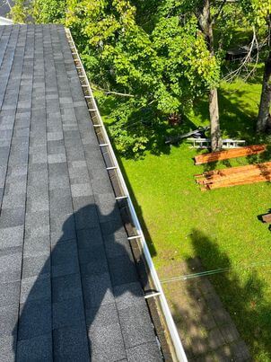 Before preventive service: Candiac gutter partially blocked by leaves and asphalt granules